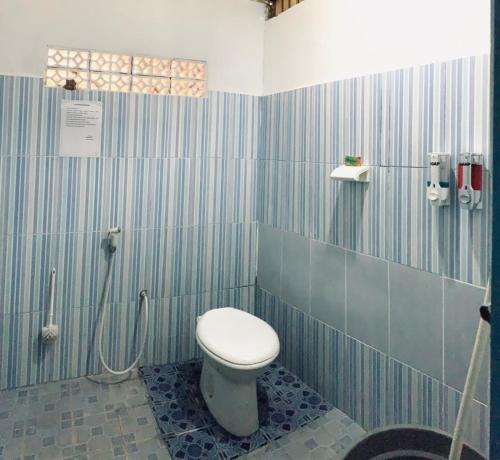 a bathroom with a toilet and a shower at Koto Hilalang Homestay in Bukittinggi