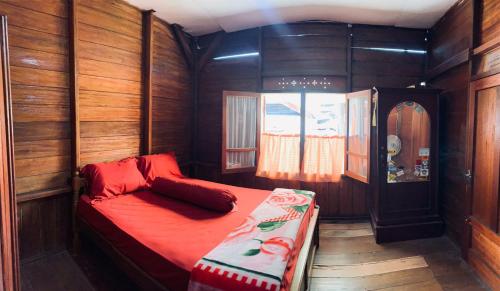 um quarto com uma cama num quarto de madeira em Koto Hilalang Homestay em Bukittinggi