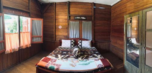 a bedroom with a bed in a room with wooden walls at Koto Hilalang Homestay in Bukittinggi