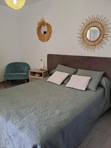 1 cama con 2 almohadas y espejo en la pared en Villa Jasmin, en Sainte-Rose