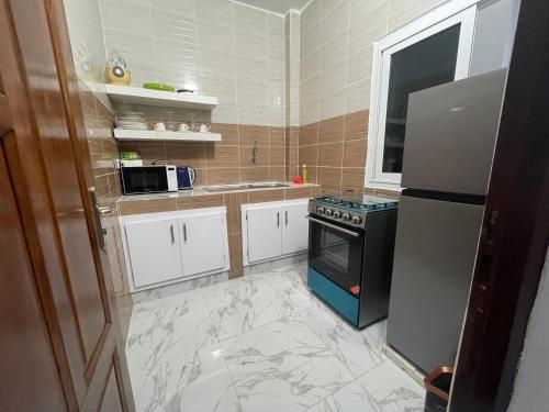 Il comprend une cuisine équipée d'un réfrigérateur et d'une cuisinière. dans l'établissement Résidence KANN, à Dakar