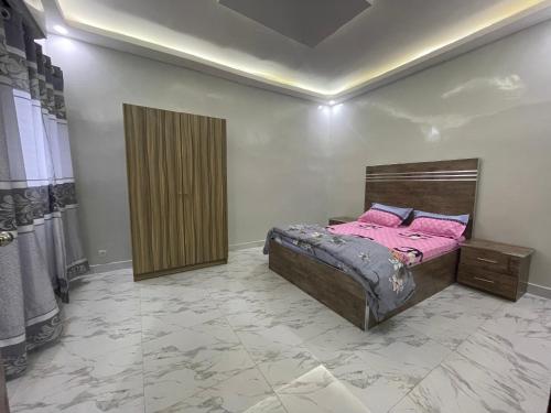 une chambre avec un lit avec des oreillers roses dessus dans l'établissement Résidence KANN, à Dakar