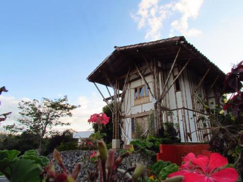 a house with a balcony and flowers in front of it at Hotel La Montoya in Curití