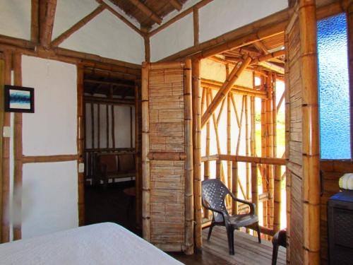 um quarto com uma cama e uma cadeira num quarto em Hotel La Montoya em Curití