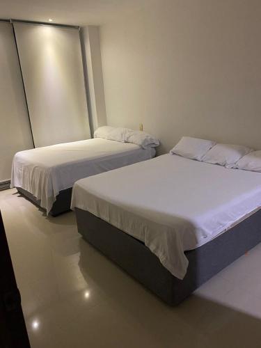 two beds in a small room withermottermottermott at Laguna club zona norte - se renta con vehículo in Cartagena de Indias