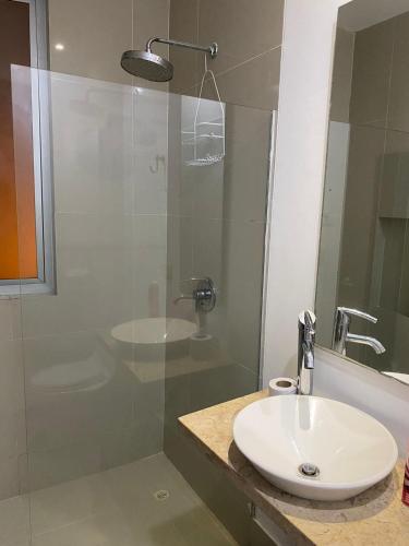 a bathroom with a sink and a glass shower at Laguna club zona norte - se renta con vehículo in Cartagena de Indias