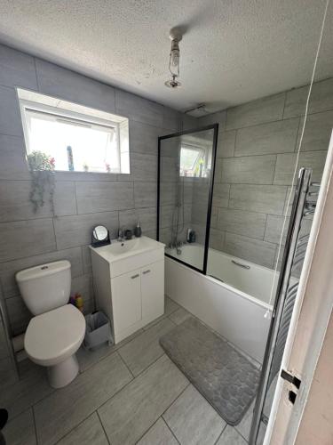 a bathroom with a toilet and a tub and a sink at Lovely one bedroom apartment in Thornton Heath