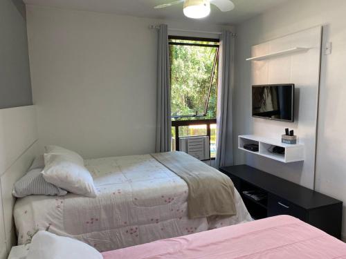 En eller flere senge i et værelse på Apto Riviera Piscina Aquecida