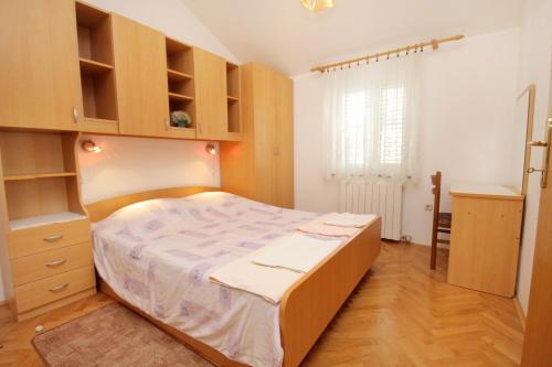 a bedroom with a large bed and wooden cabinets at Apartments with a parking space Krk - 5371 in Krk