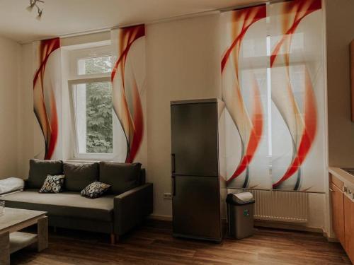 salon z kanapą i lodówką w obiekcie Unser sonniges Apartment mit WLAN, Netflix, XBox w mieście Magdeburg
