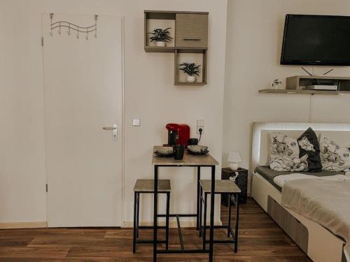 1 dormitorio con cama, mesa y TV en Unser sonniges Apartment mit WLAN, Netflix, XBox en Magdeburgo
