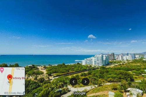 a view of the ocean and a city with a sign at Apto Vista Mar 2 cuadras Playa, Jaccuzi BBQ Wifi Parqueadero y Ascensor 7 Piso in Santa Marta