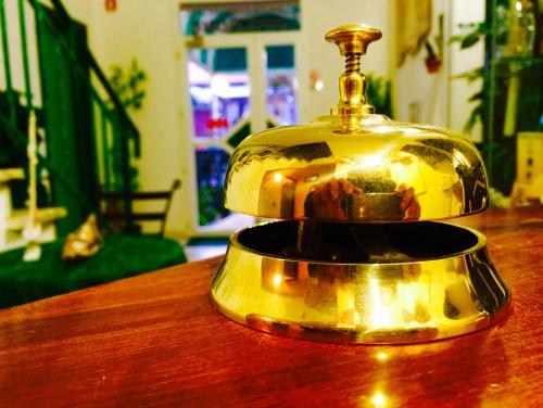 a gold bell sitting on top of a wooden table at Lungomare Hotel in Marina di Cecina