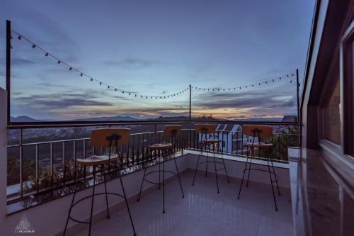 a balcony with chairs and a view of a city at La Villa Da Lat in Khu Chi Lăng