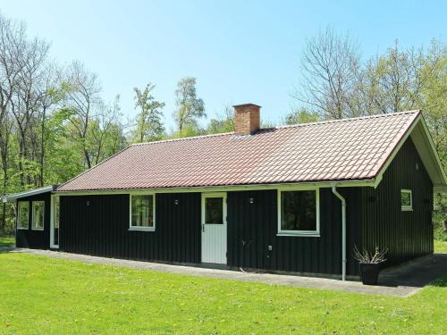 una casa negra con techo rojo en 6 person holiday home in Hadsund, en Odde