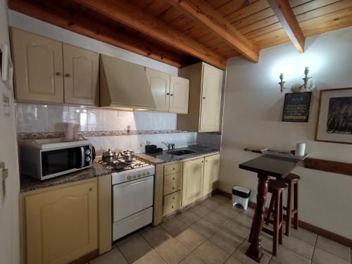 a kitchen with white appliances and a table in it at Holiday Home Las Retamas in San Martín de los Andes