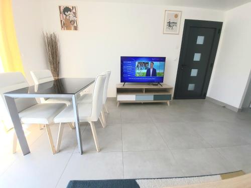 a dining room with a table and a television at Appartement cosy proche Paris Orly - Climatisé in Morangis