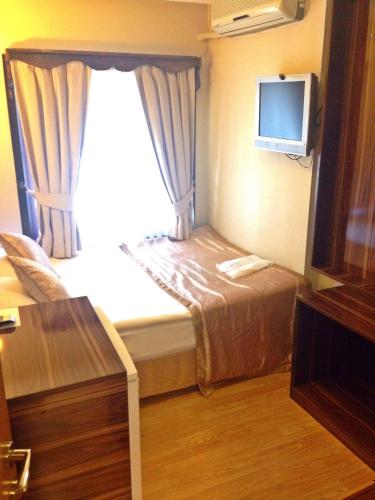 a hotel room with a bed and a television at Naz Wooden House Inn in Istanbul