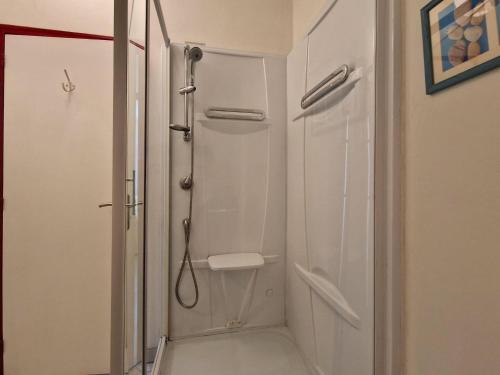 La salle de bains est pourvue d'une douche blanche. dans l'établissement Apartment, Erquy, à Erquy