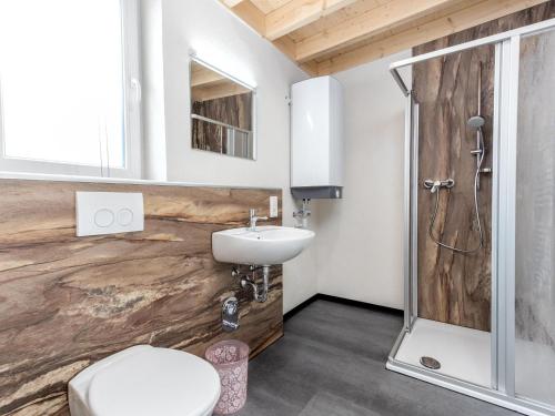 a bathroom with a toilet and a sink and a shower at Eifel Countryside Comfort in Hallschlag