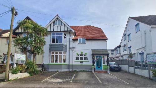 a white house with a blue door on a street at The Miggi vegan guesthouse in Torquay