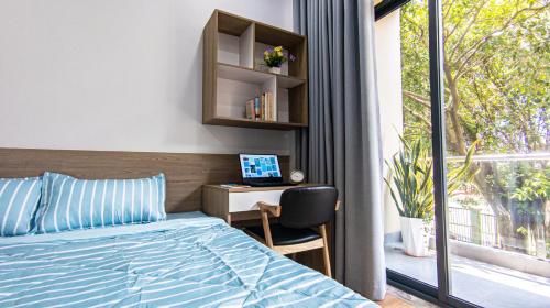 a bedroom with a bed and a desk with a computer at Marki Home in Ho Chi Minh City