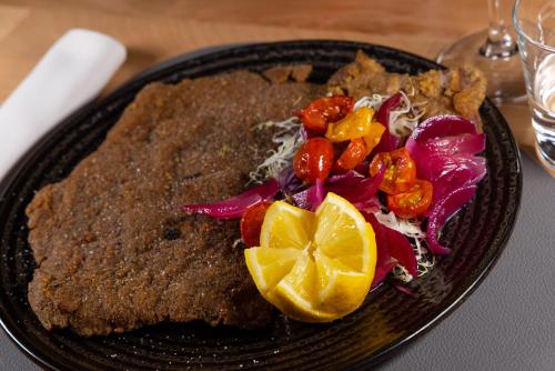 a black plate with food on a table at Garden Wellness Hotel S in Andalo