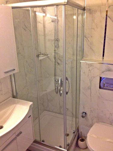 a shower with a glass door in a bathroom at Naz Wooden House Inn in Istanbul