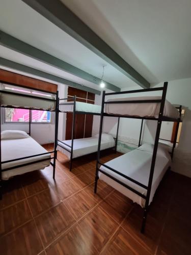 three bunk beds in a room with a wooden floor at Casa Alvarado Hostel in Salta