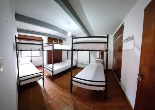 a room with three bunk beds in it at Casa Alvarado Hostel in Salta