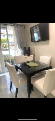 a dining room with a black table and white chairs at Ocho Rios Vacation Resort Property Rentals in Ocho Rios
