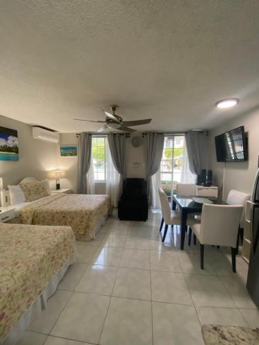 a hotel room with two beds and a table and chairs at Ocho Rios Vacation Resort Property Rentals in Ocho Rios