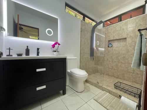 a bathroom with a shower and a toilet and a sink at Lujo y Naturaleza Junto al Río a 10 min de Playas Montezuma y Santa Teresa in Cóbano