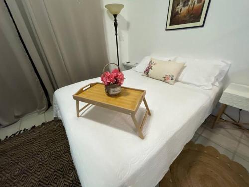 a bed with a wooden table with flowers on it at Lujo y Naturaleza Junto al Río a 10 min de Playas Montezuma y Santa Teresa in Cóbano