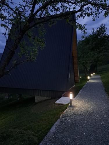 a building with lights on the side of a road at Fern Farm Tiny Home in Mojkovac