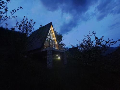 a building with a lit up window at night at Fern Farm Tiny Home in Mojkovac