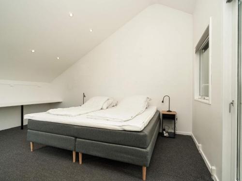 een slaapkamer met een bed in een witte kamer bij Holiday home Græsted XI in Græsted