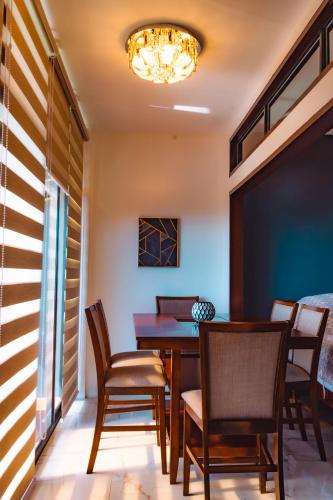 a dining room with a table and chairs and a chandelier at Marqis Sunrise Sunset Resort and Spa in Baclayon