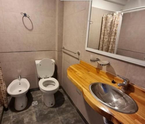 y baño con lavabo, aseo y espejo. en Complejo Aires 3 en San Bernardo