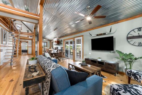 ein Wohnzimmer mit Sofa und Fernseher in der Unterkunft Hollmig Haus - Sleeps 12 with Hot Tub & Beauty Bar in Fredericksburg