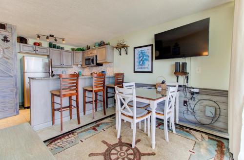 a kitchen with a table and chairs and a television at 0312 Captains Quarters by Atlantic Towers in Carolina Beach