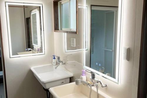 baño con lavabo y 2 espejos en Guest house yamahide, en Tatsugo