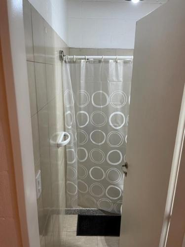 a shower with a shower curtain in a bathroom at Cómodo depto en Comodoro Rivadavia! in Comodoro Rivadavia