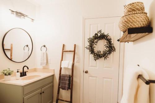 a bathroom with a sink and a door with a mirror at @wild_olive_den ~ Serene Weekend Getaway Cabin in Running Springs