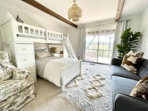 a bedroom with a white bunk bed and a couch at @wild_olive_den ~ Serene Weekend Getaway Cabin in Running Springs