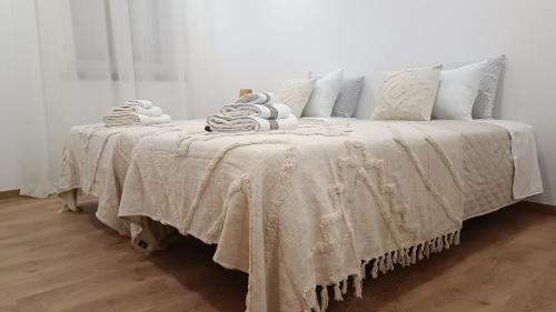 a bed with a white blanket and pillows on it at Mondalva Apartamentos in São Pedro de Alva