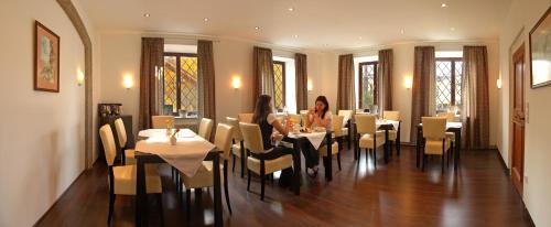 een vrouw aan een tafel in een restaurant bij Hotel Pension Herbert in Salzburg