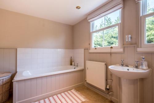a bathroom with a bath tub and a sink at Sandy Lodge Rock in Padstow
