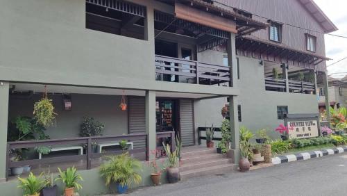 a building with potted plants in front of it at Country View Inn in Sungai Lembing