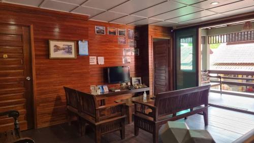 a room with a desk and a tv and a bench at Country View Inn in Sungai Lembing